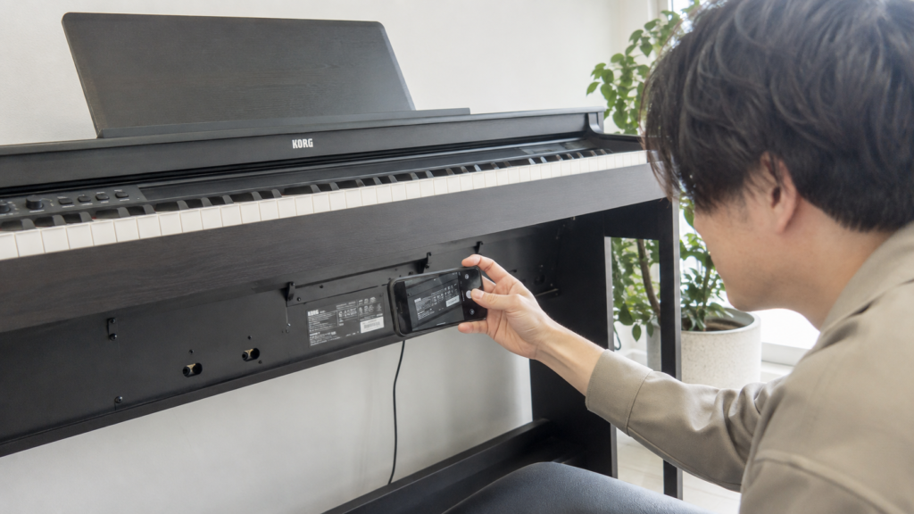KORG電子ピアノの型番や製造番号を確認する様子