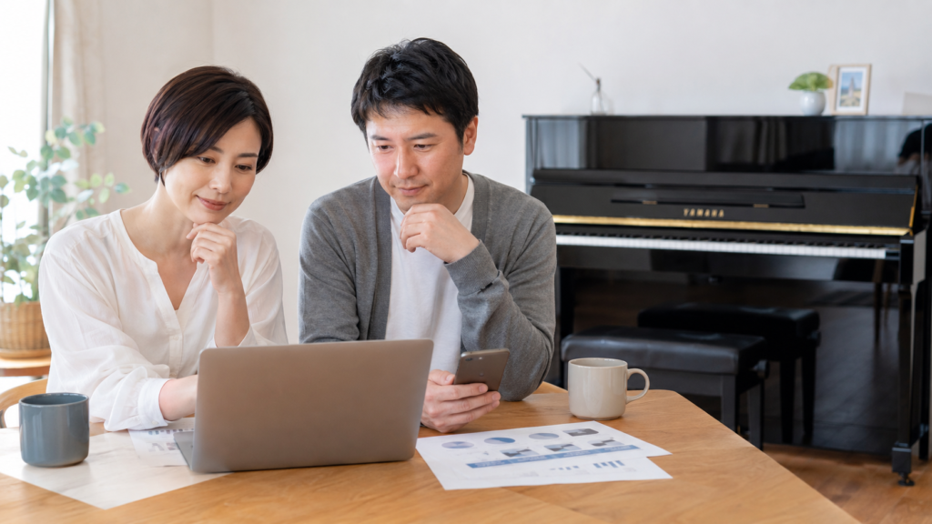 ピアノ買取の査定額をパソコンで比較する夫婦とYAMAHAピアノ