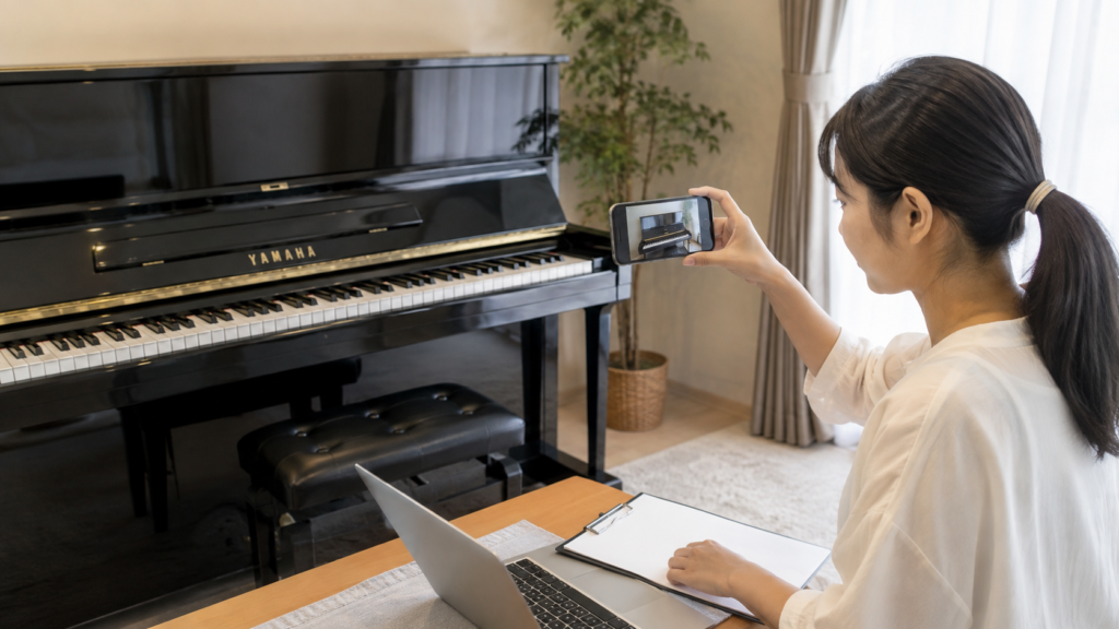 運搬前にアップライトピアノを撮影して買取査定を準備する女性